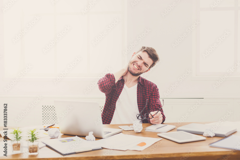 Tired, overworking businessman with laptop in modern white office Tired, overworking businessman with laptop in modern white office