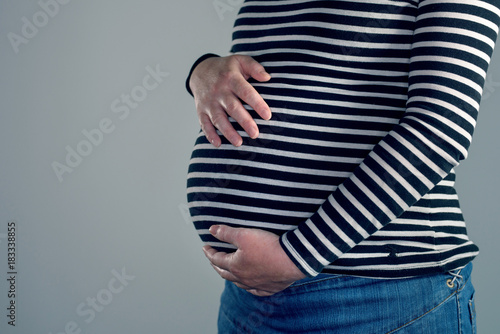 Close-up of pregnant woman with hands over tummy