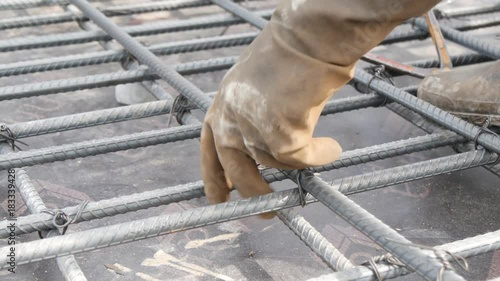 worker preparing bundle wire on steel bar in construction site