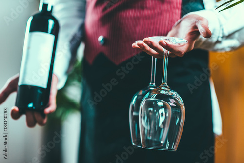 Photo Sommelier holding wine bottle and wine glasses