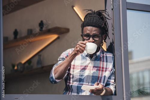 african american man drinking coffee in cafe