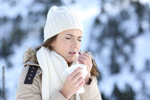 Woman taking a pill in a cold snowy winter
