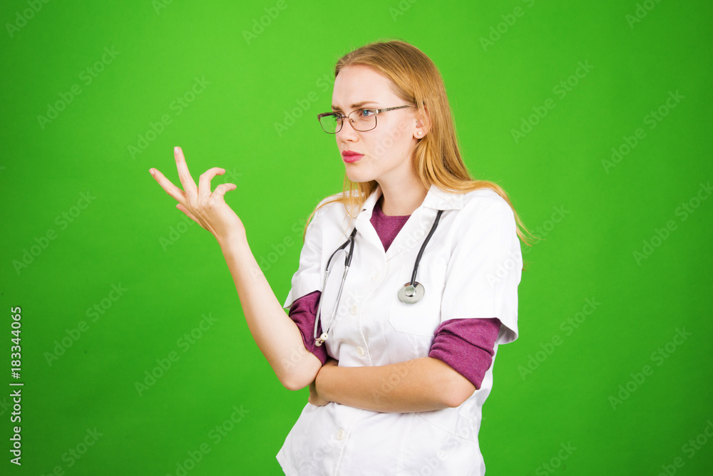 Young female doctor isolated on green background with stethoscope screaming and body sign gesture woman blond medical concept Young female doctor isolated on green background with stethoscope screaming and body sign gesture woman blond medical concept