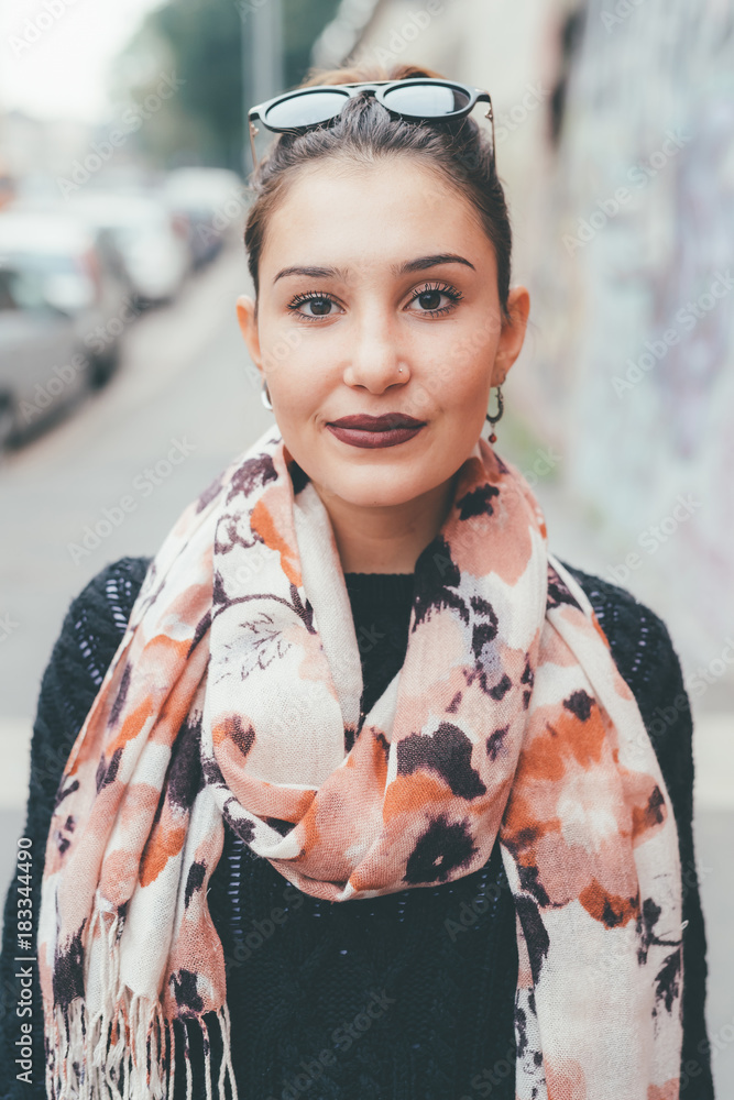 Fototapeta premium portrait of young woman outdoors looking camera smiling - happiness, serene, customer concept