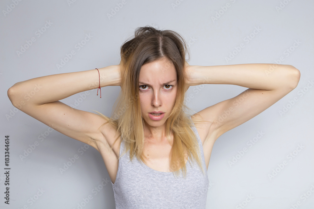 Beautiful brunette caucasian woman in grey blouse with bright emotions standing on a neutral grey background. Her hands make a gesture. She act sexy, seductive Beautiful brunette caucasian woman in grey blouse with bright emotions standing on a neutral grey background. Her hands make a gesture. She act sexy, seductive