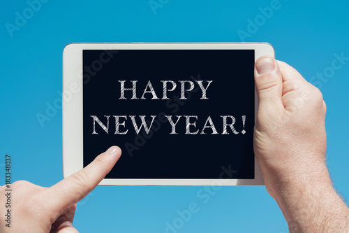 Man holding a tablet device with text "Happy new year"