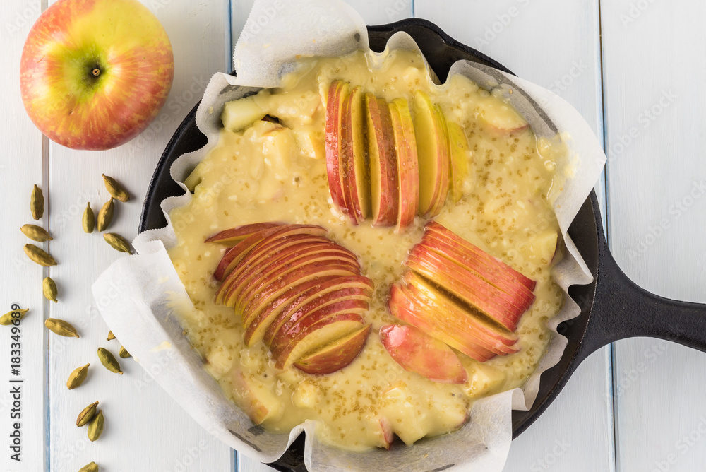 Unbaked cardamom cognac apple cake in iron skillet. Unbaked cardamom cognac apple cake in iron skillet.