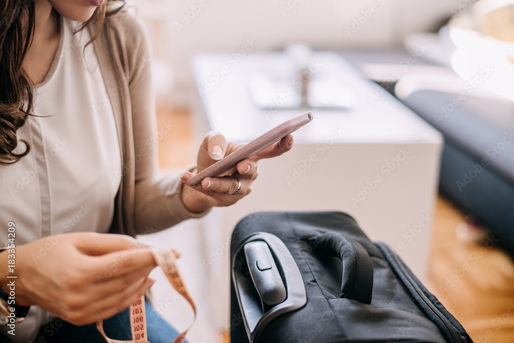 Fototapeta premium Woman buying plane ticket on phone.