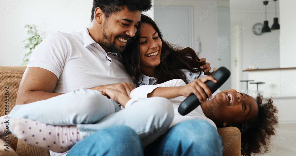 Happy family watching television at their home Happy family watching television at their home