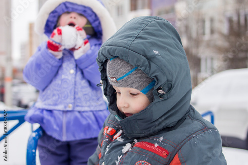 brother and sister play in the winter on the playground