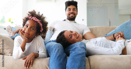 Young girl watching tv with her parents