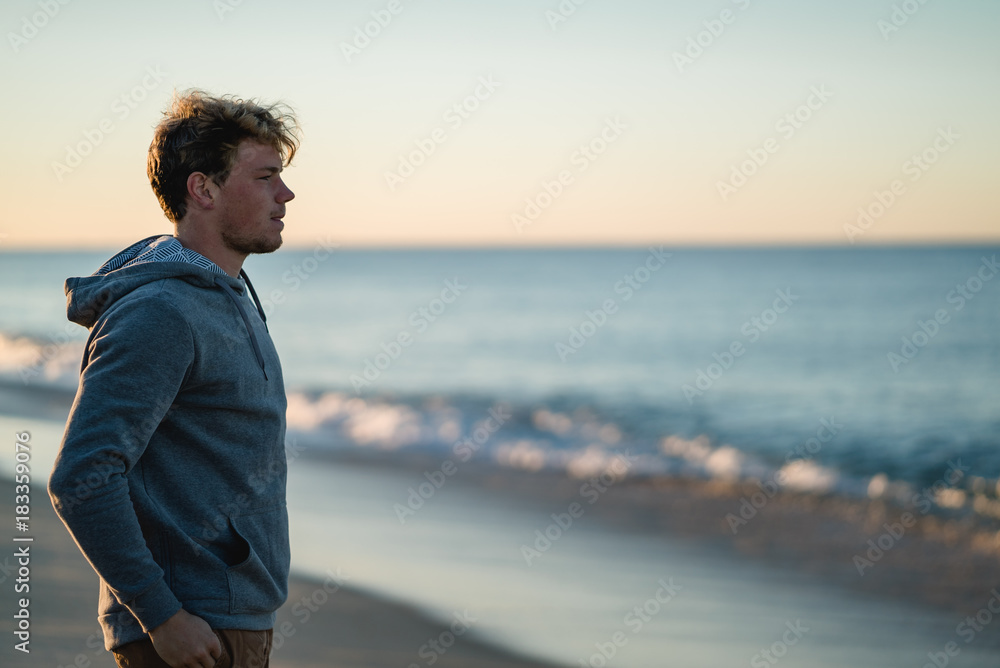 Man watching the sunrise and walking around on the beach in Portugal