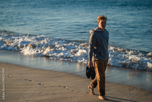 Man watching the sunrise and walking around on the beach in Portugal
