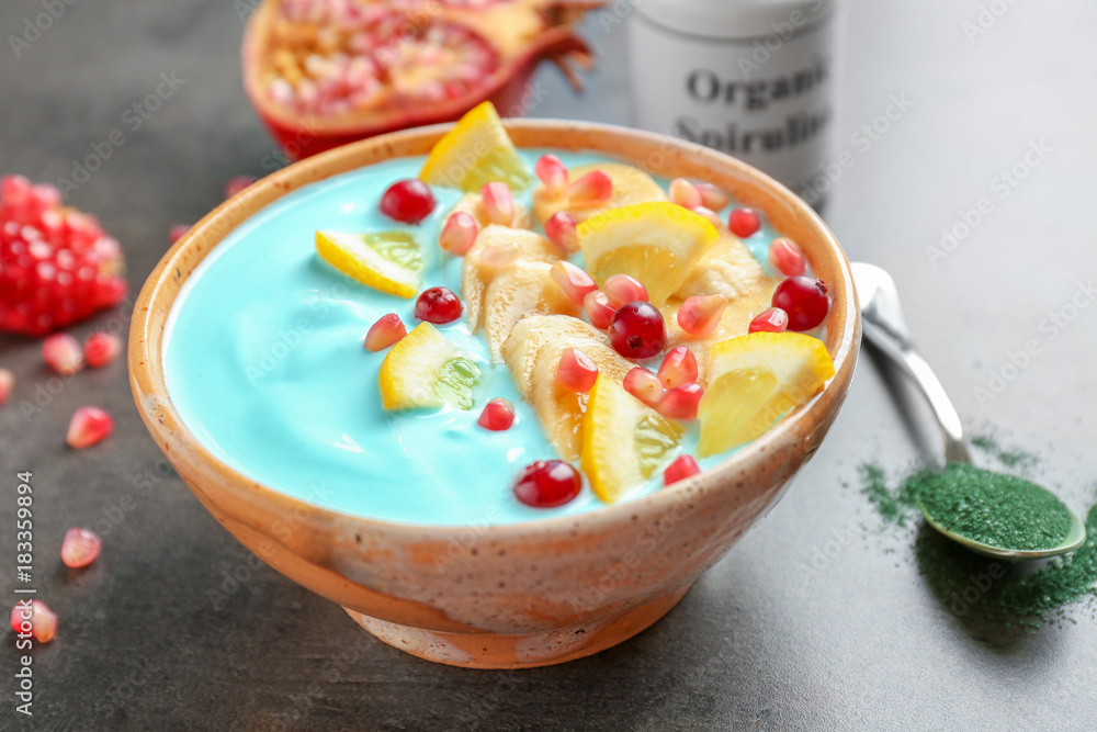 Bowl with blue spirulina smoothie on table. Healthy vegan food concept Bowl with blue spirulina smoothie on table. Healthy vegan food concept