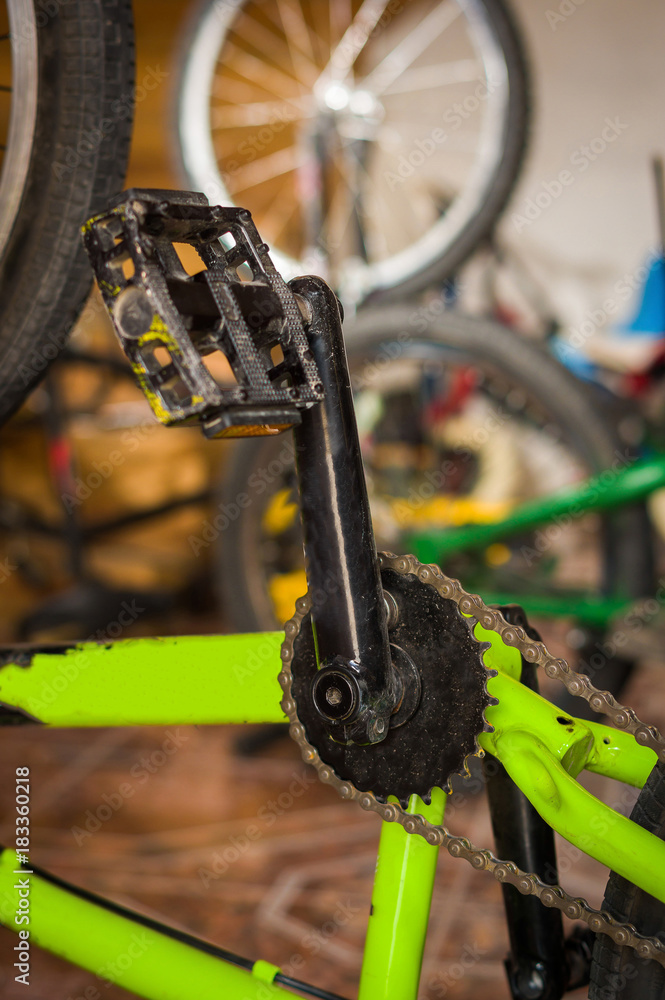 Close up of Bicycle pedal fixed by a mechanic in a workshop, in blurred background Close up of Bicycle pedal fixed by a mechanic in a workshop, in blurred background