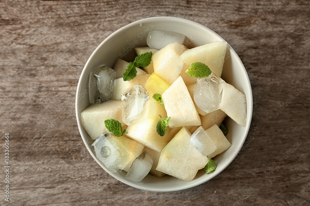 Bowl with yummy melon slices on wooden table Bowl with yummy melon slices on wooden table