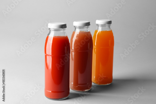 Bottles with juices on light background