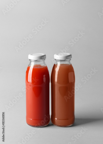 Bottles with juices on light background