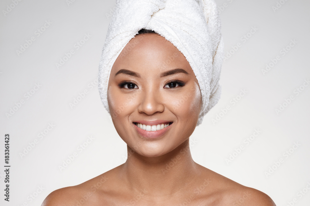 Attractive lady without make up with towel on head smiling to camera Attractive lady without make up with towel on head smiling to camera