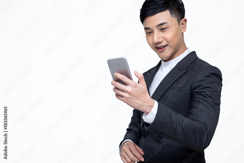 Young Asia businessman looking at mobile phone and smiling on whit background with clipping path Young Asia businessman looking at mobile phone and smiling on whit background with clipping path
