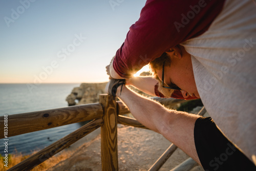 Man stretching at sunset on a cliff
