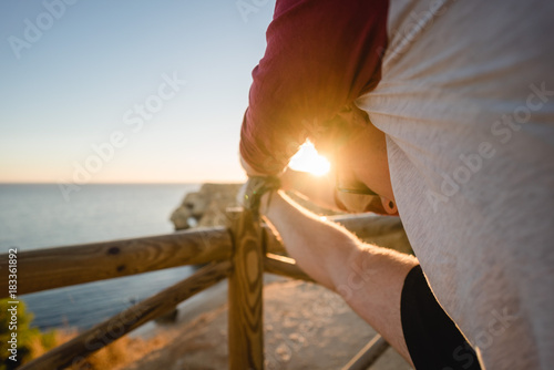 Man stretching at sunset on a cliff