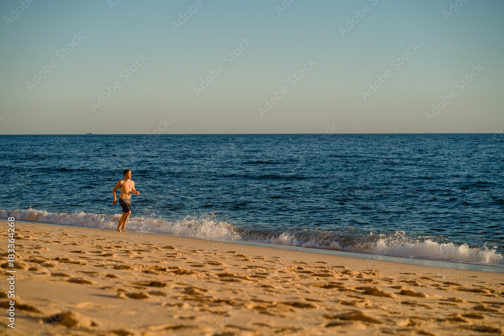 Man running on the beach at sunset Man running on the beach at sunset