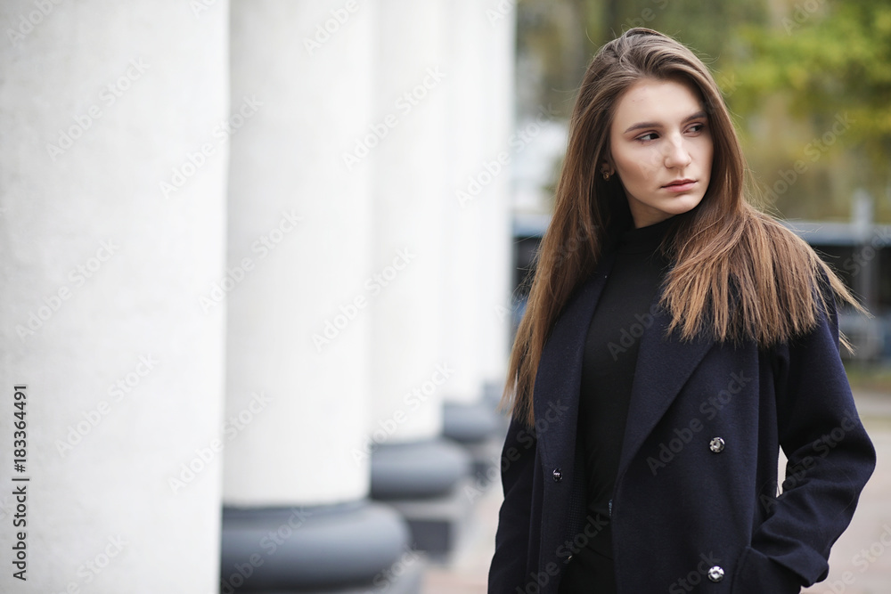 Beautiful girl in a coat in business downtown 