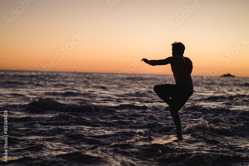 Man doing yoga on a rock in Portugal