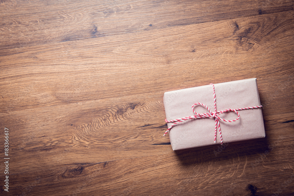 Brown gift box with red ribbon on wooden background with copy space. Brown gift box with red ribbon on wooden background with copy space.