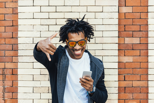 Afro young man using mobile phone. photo