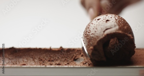 Soft spongy chocolate mousse taken out of a stainless steel pan with a teaspoon isolated on white