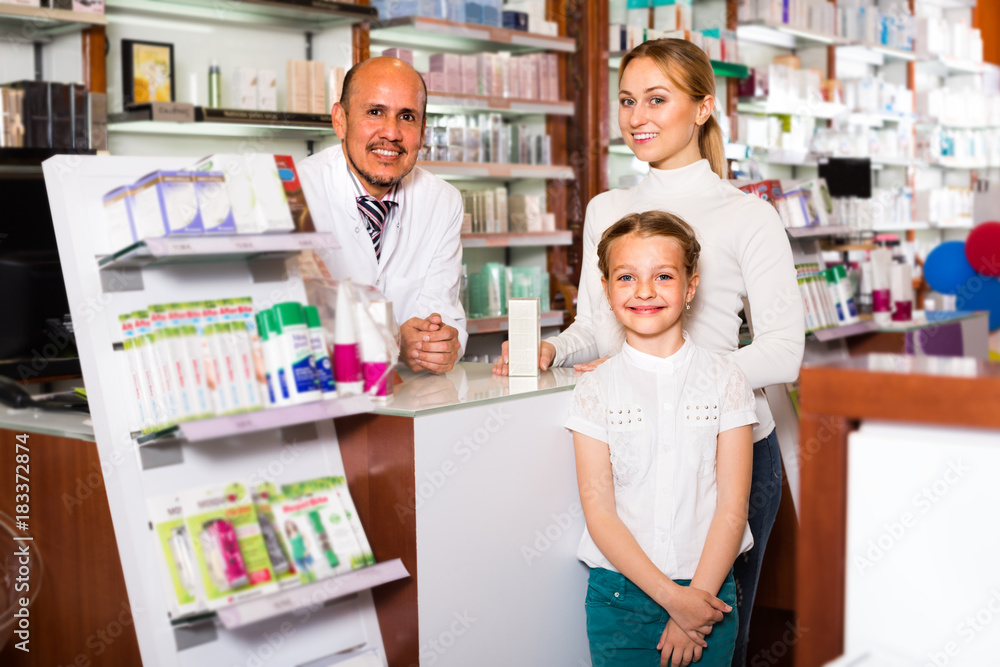 pharmacist standing with a cash desk