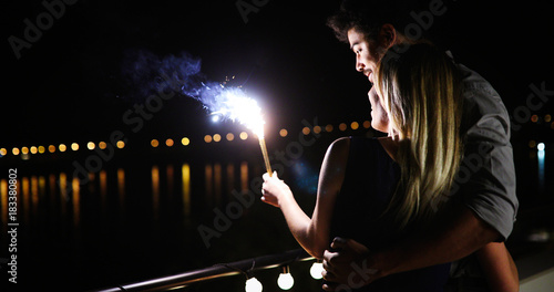 Picture of happy couple holding burning sparkle