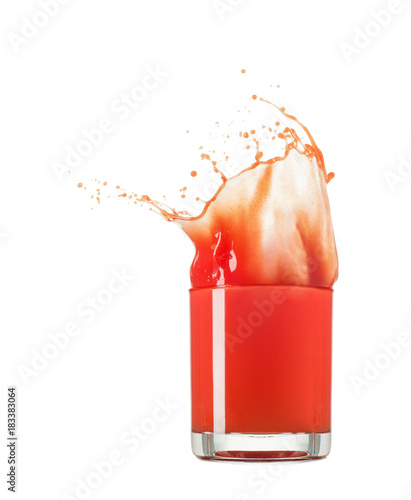 Glass of splashing tomato juice isolated on white. Tomato splash photo