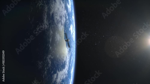 Flying satellite. The satellite appears in the frame and flies away. The earth is on the screen to the left.. 4K. photo