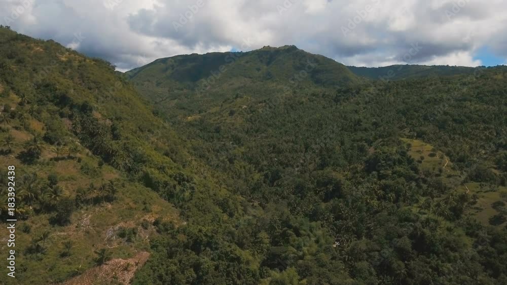 Mountains with rainforest covered with green vegetation and trees on the tropical island, landscape. Aerial view: Mountains and hills with wild forest, sky clouds. Hillside rainforest and jungle Mountains with rainforest covered with green vegetation and trees on the tropical island, landscape. Aerial view: Mountains and hills with wild forest, sky clouds. Hillside rainforest and jungle