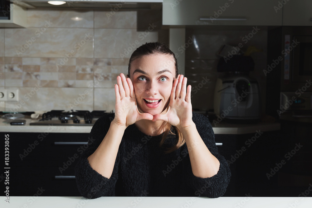 Young happy woman making a face and showing her palms Young happy woman making a face and showing her palms