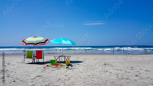 Sun umbrellas at the beach with children's toys on a sunny day