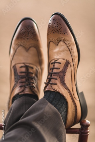 Cropped image of male brown shoes on men