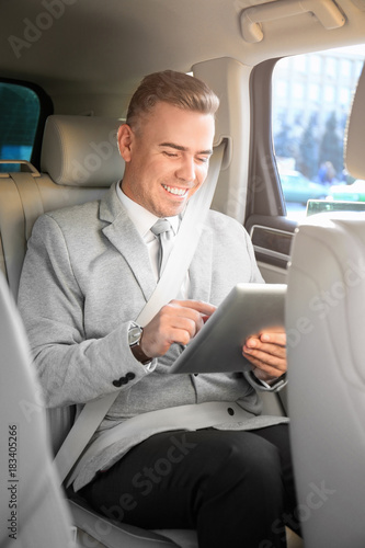 Man in formal wear with tablet computer in car © Africa Studio