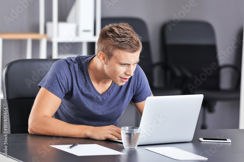 Handsome man with laptop in office