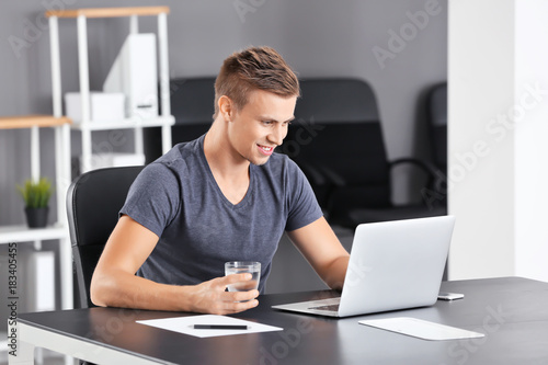 Handsome man with laptop an...