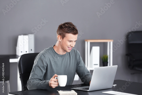 Handsome man with laptop an...