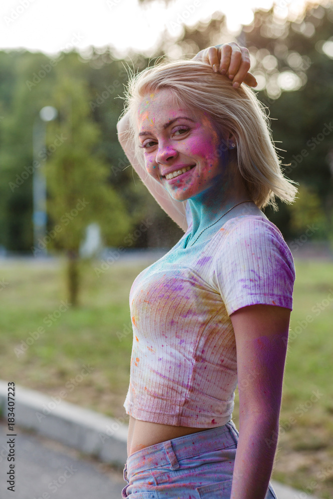 Nice young woman in white t shirt and blue jeans shorts covered with dry  colorful paint Holi, Gulal Stock Photo | Adobe Stock