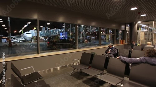 Man with a smartphone waiting for the announcement of the boarding on aircraft