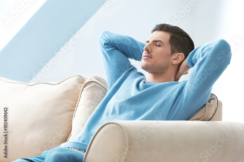 Happy young man relaxing at...