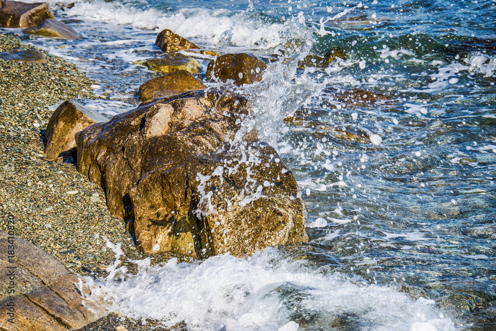 Naklejka premium Scenic water splash and a rock in ocean