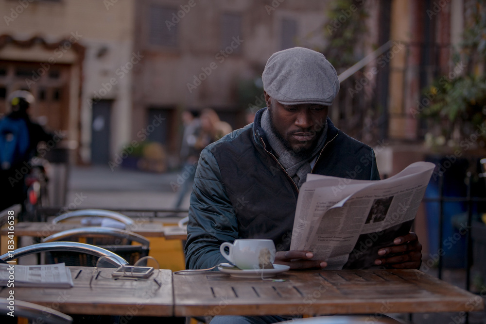 Reading newspaper at outdoor cafe Reading newspaper at outdoor cafe