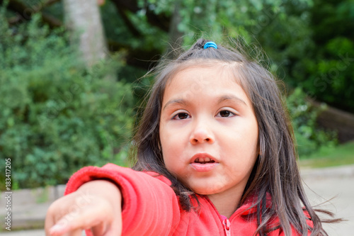 Little latin girl pointing her finger.